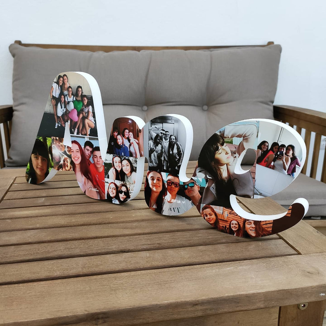Nombre Ane en letras 3D unidas decorado con fotos sobre una mesa